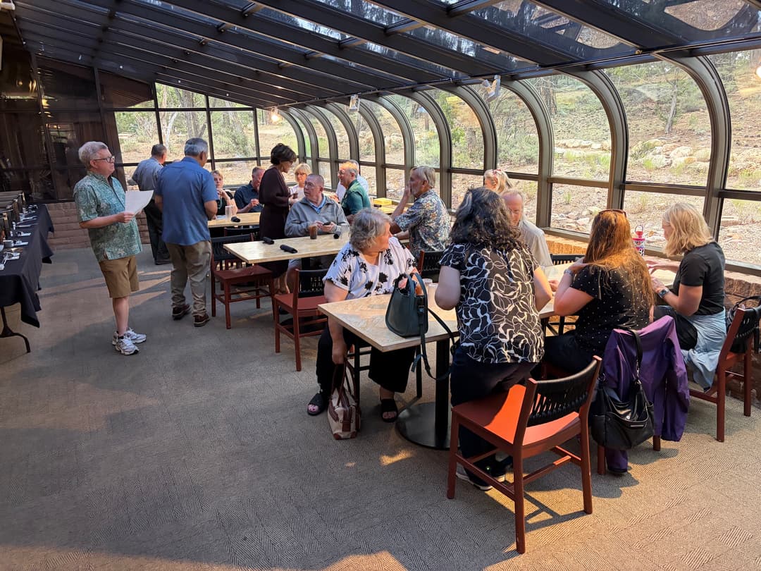 NALA members seated at tables in a glass-walled sunroom as the dinner program begins.